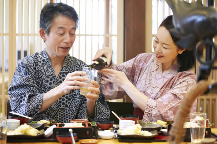 温泉宿で食事をするシニア夫婦