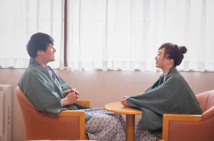 カップルが宿で談笑している写真