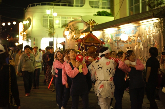 どんつく祭りで女性が神輿を担いでいるところ