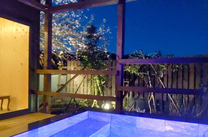 和の湯が夜にライトアップされている様子と河津桜
